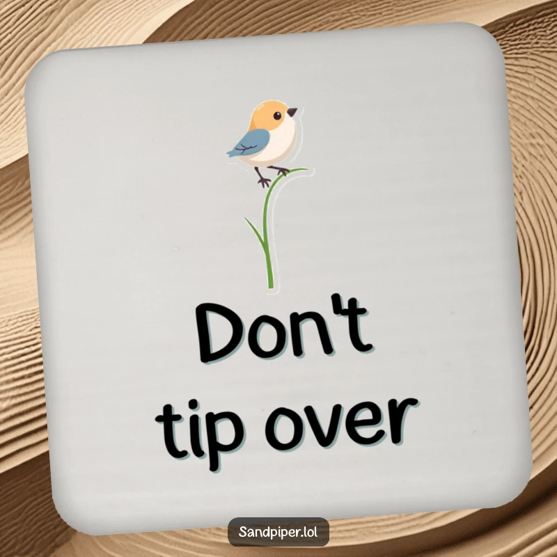 Funny drink coaster with a bird shape precariously balancing on a single, thin blade of grass, adding humor to surfaces.