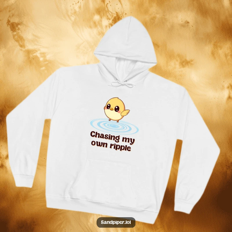 Funny hoodie depicting a small bird with huge, curious eyes zealously chasing a bouncing water ripple, radiating pure fun.