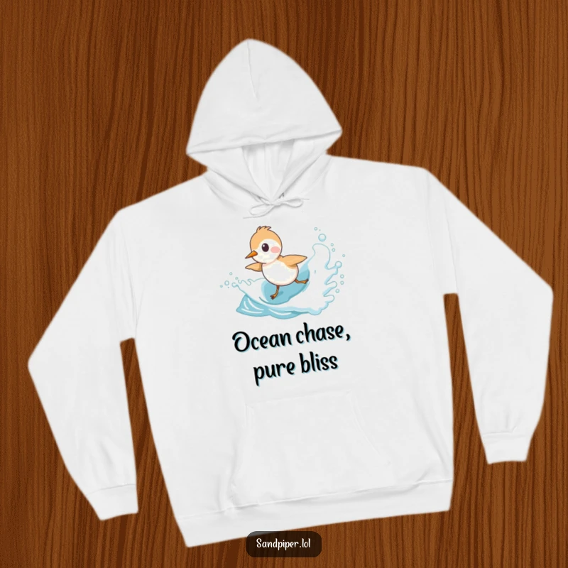 Funny Sandpiper Hoodie featuring a cute bird character playfully chasing an ocean wave, designed for cozy seaside humor.